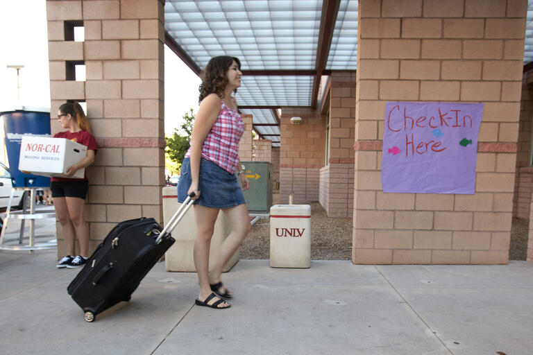 Student walking her luggage.