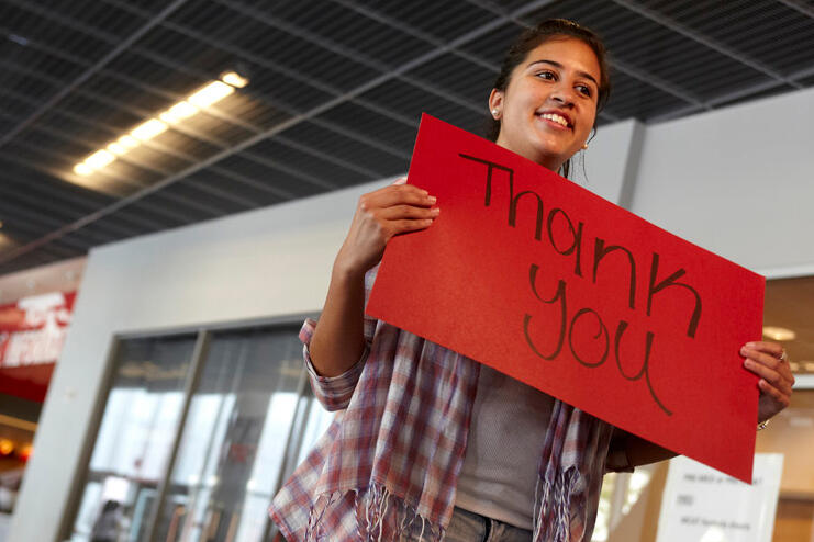 Student holds up a thank you sign