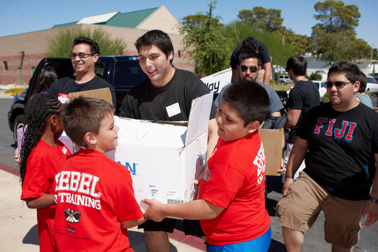Younger kids help out rebel students move boxes.