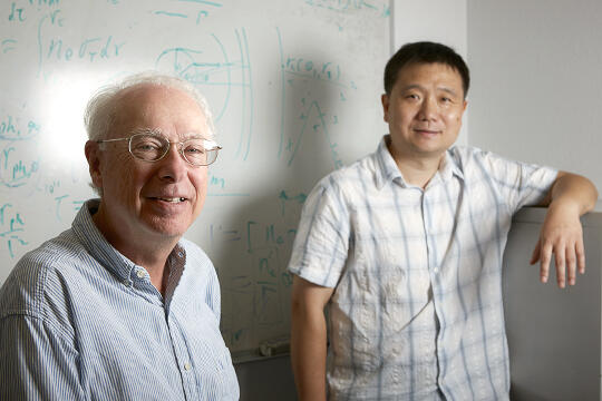 Donor Russell Frank and astrophysics professor Bing Zhang standing in front of a whiteboard.