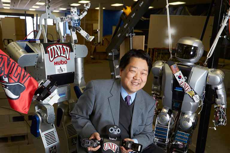 Paul Oh poses with a few of his robots