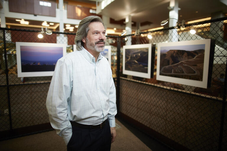 Aaron Mayes stands in front of his photos