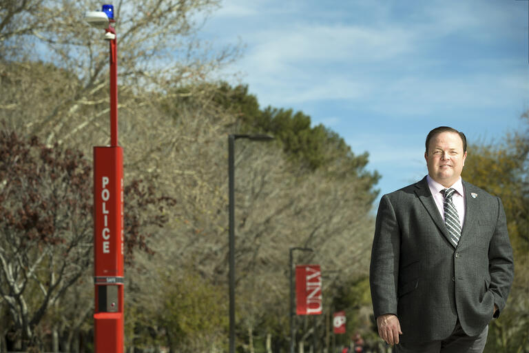 Portrait of Yuri Graves, UNLV's first emergency manager, stands by a call box.