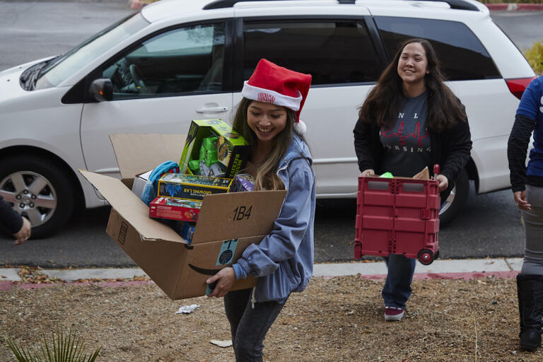 UNLV students carrying boxes of gifts