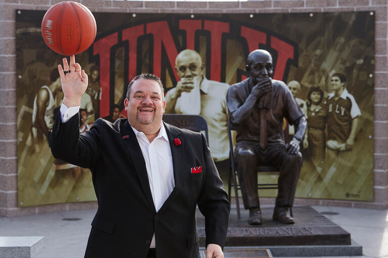 Joe Esposito, special assistant to head basketball coach Marvin Menzies, poses in front of the Tarkanian statue in front of the Thomas &amp; Mack Center.