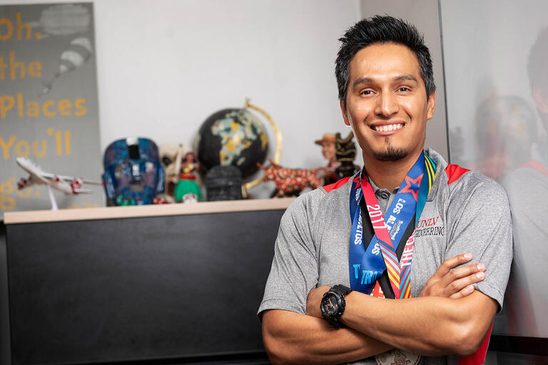 Portrait of Daniel Mendoza with ribbons around his neck displayig sports medlas he has won.