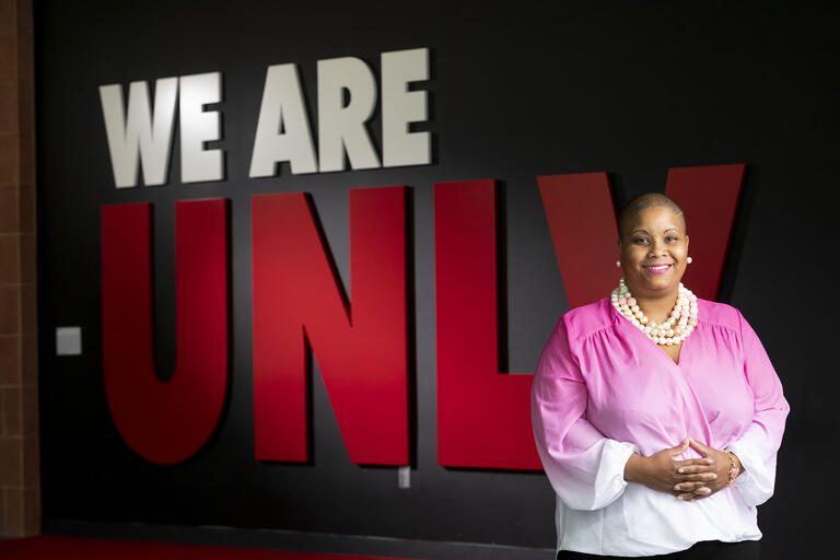 Renee Watson stands in front of &quot;We Are UNLV&quot; sign.