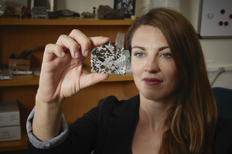 u.n.l.v. professor arya udry looks at a meteorite that she is holding up to the light