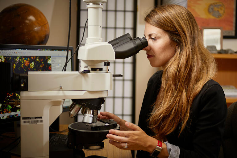 Arya Udry using a microscope.