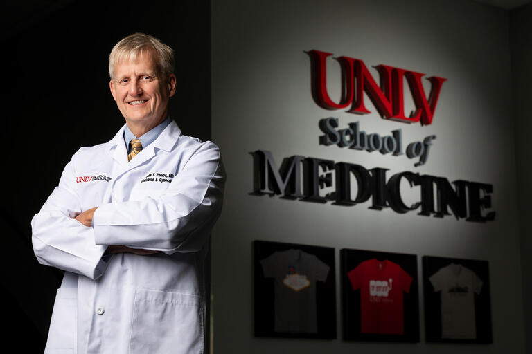 Dr. John Phelps, poses in front of the UNLV School of Medicine sign.