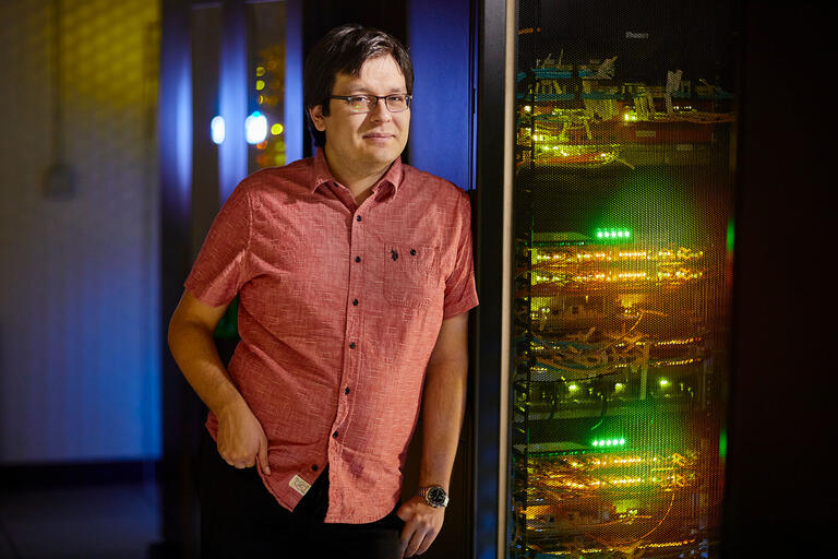 Computer Science Faculty-In-Residence Jorge Fonseca by server racks.