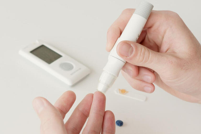 A close-up of a person using a diabetes test kit