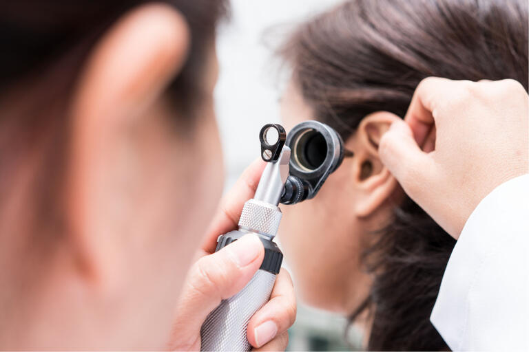 Doctor looking inside a patient's ear
