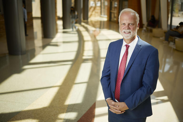 A portrait of Edmund “Ed” Synakowski, wearing a suit and tie.