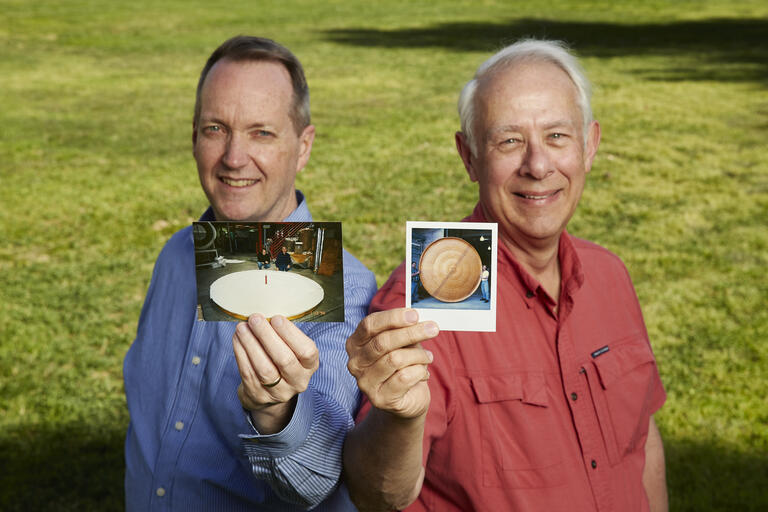 two men holding old photos