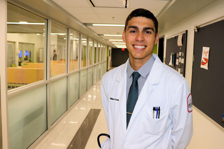 man in doctor's coat in hospital hallway