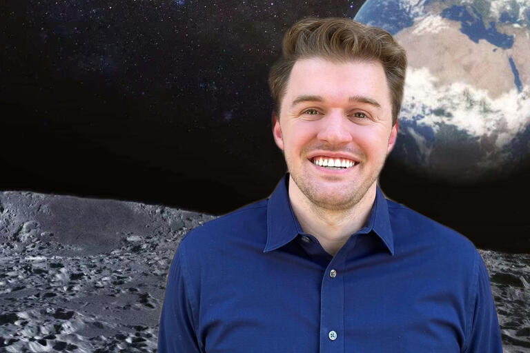 man posing with photo of earth and moon from space as backdrop