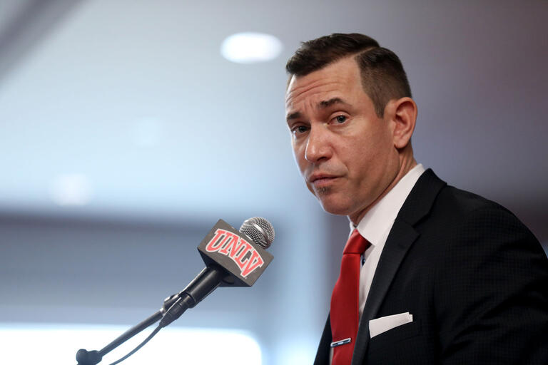 Man at microphone with UNLV logo