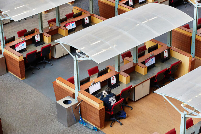 A lone student works at a bank of computers