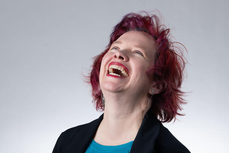 Close-up of Lisa Danielson with her head thrown back, laughing.