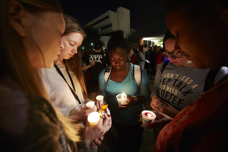 students holding candles at vigil