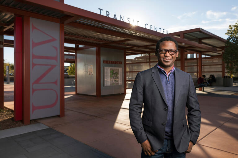 A man stands in front of UNLV's bus stop.