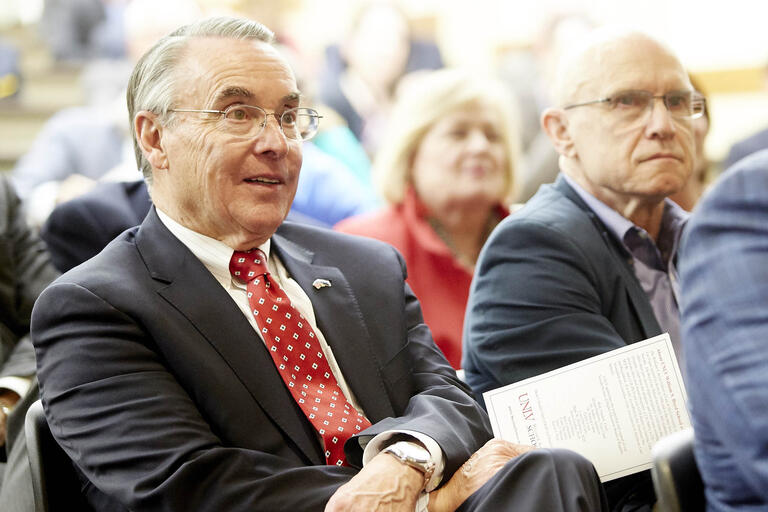man seated at event listening