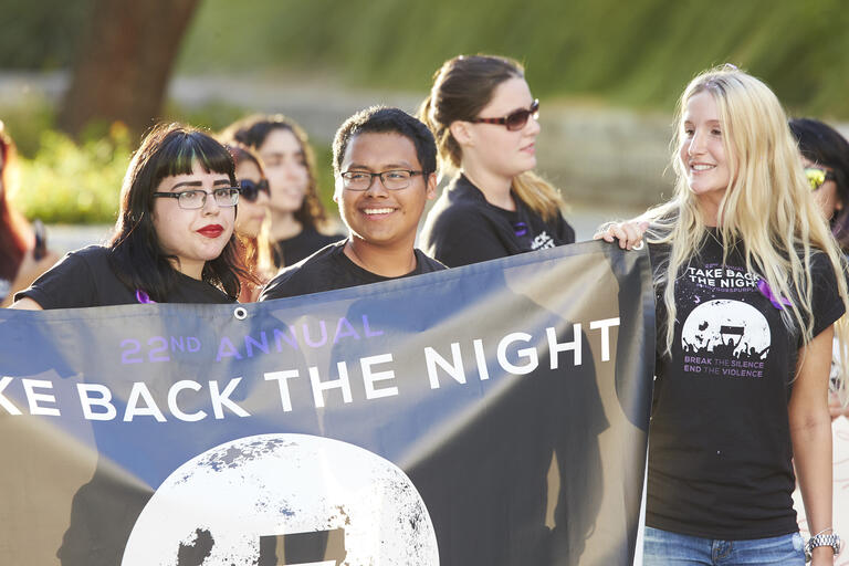 students hold up a take back the night banner