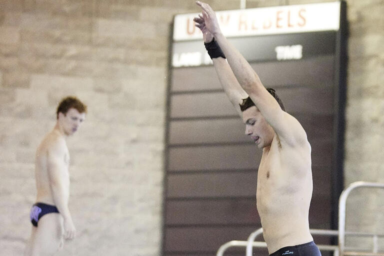 A man raises his arms as he prepares to dive.