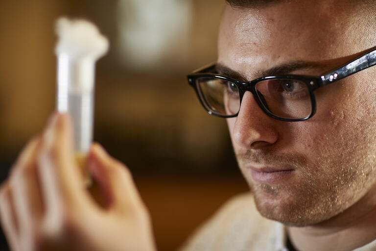 Vladislav Zhitny looks at a test tube