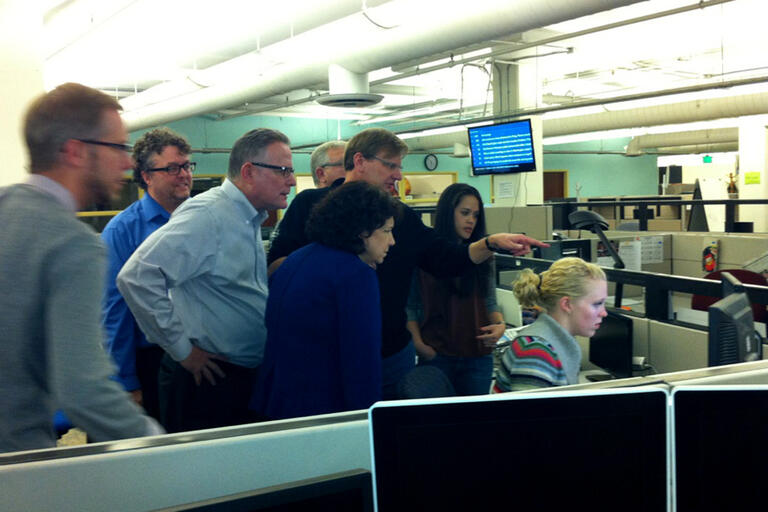 Hannah Birch, at computer, in the newsroom