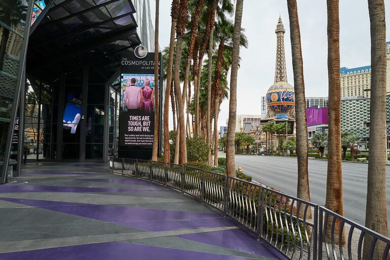 View of empty Vegas Strip walkway with sign that says: Times are tough, but so are we.