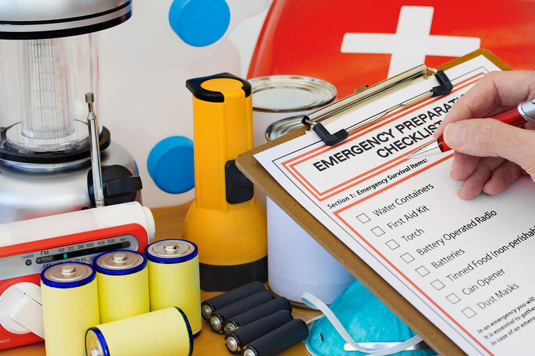 items from an emergency kit: batteries, flashlight, first aid kit