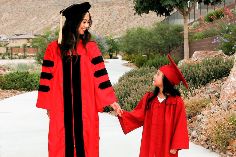 woman and child each wearing a graduation gown