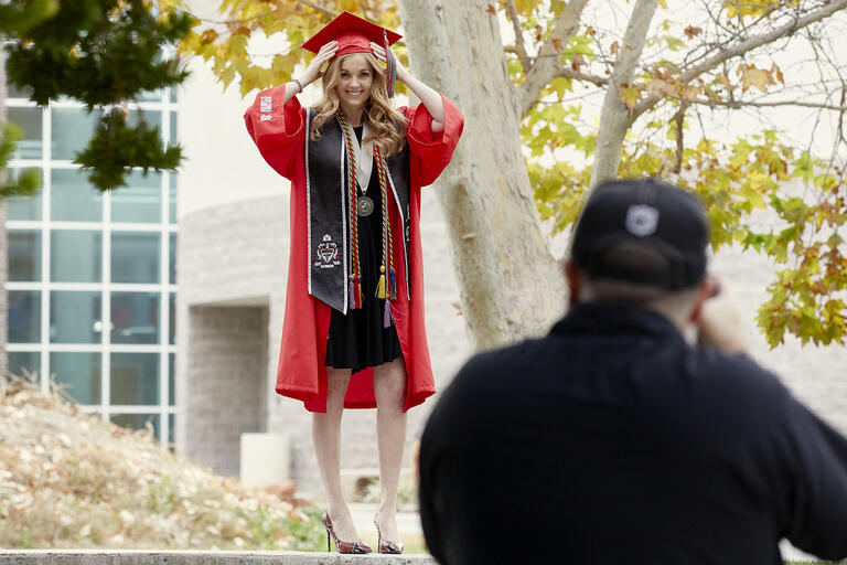 woman in commencement garb being photographed
