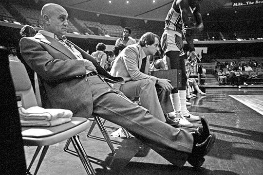 Two men sitting down at a basketball game