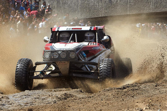 An auto racer driving in dirt