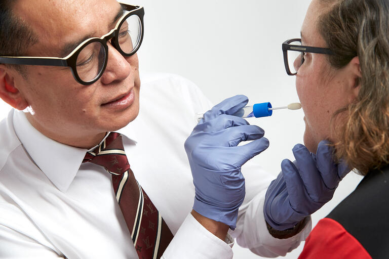 Nursing professor Jay Tan examining a person's mouth
