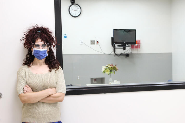 woman in mask outside an medical exam room