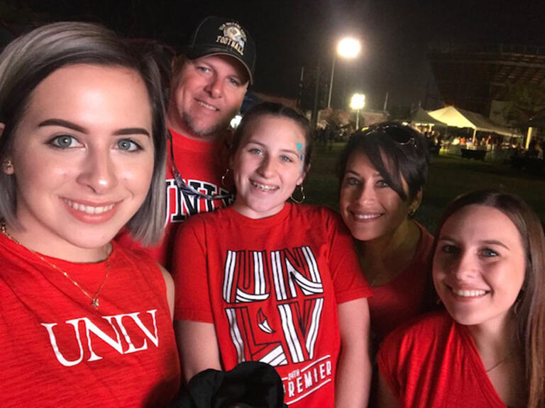 Photo of family in UNLV t-shirts outside at night