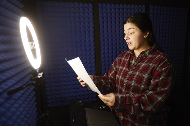 woman speaking in padded room with ring light