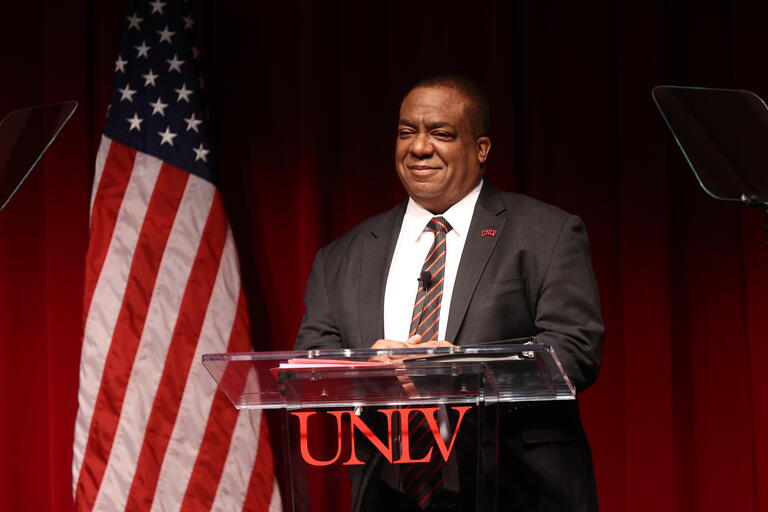 UNLV President Keith E. Whitfield stands behind a UNLV podium