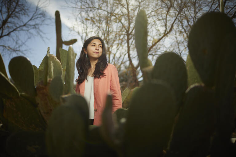 April Contreras stands behind cacti.