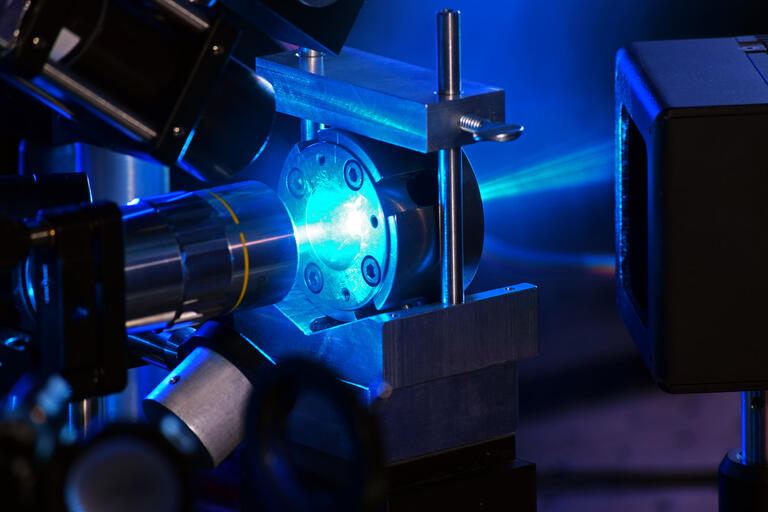 A laser beam emitting a blue light is projected into a diamond anvil cell