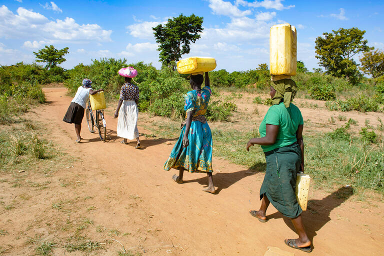 women in africa carrying water jugs
