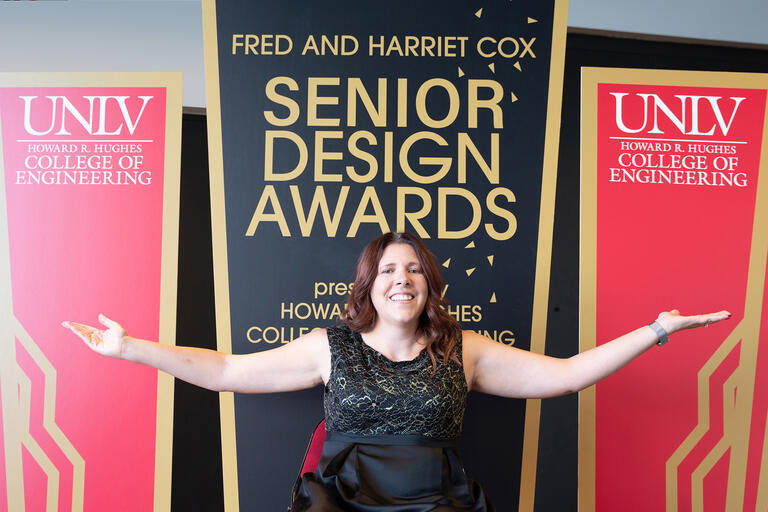 woman in front of Senior Design Awards signage