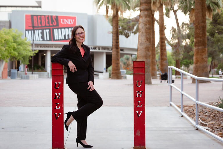 smiling woman in heels posing with unlv student union in background