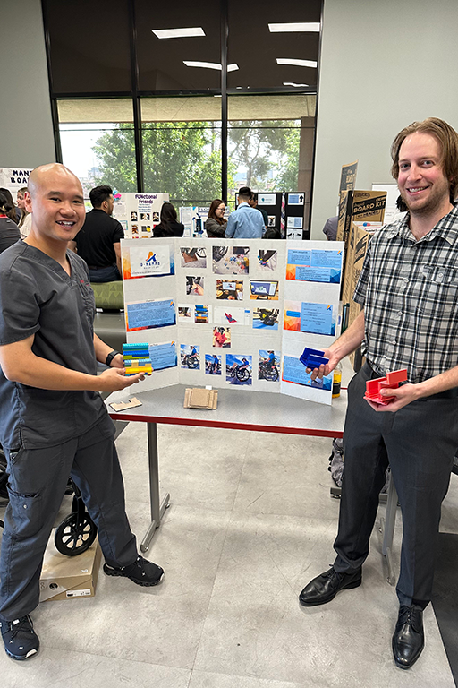 Male Occupational Therapy students presenting assistive devices at a fair