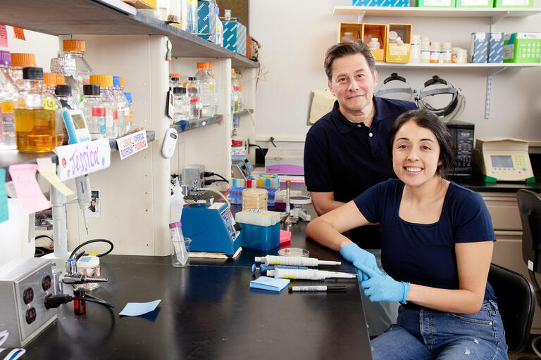 female student and male faculty member posing in science lab