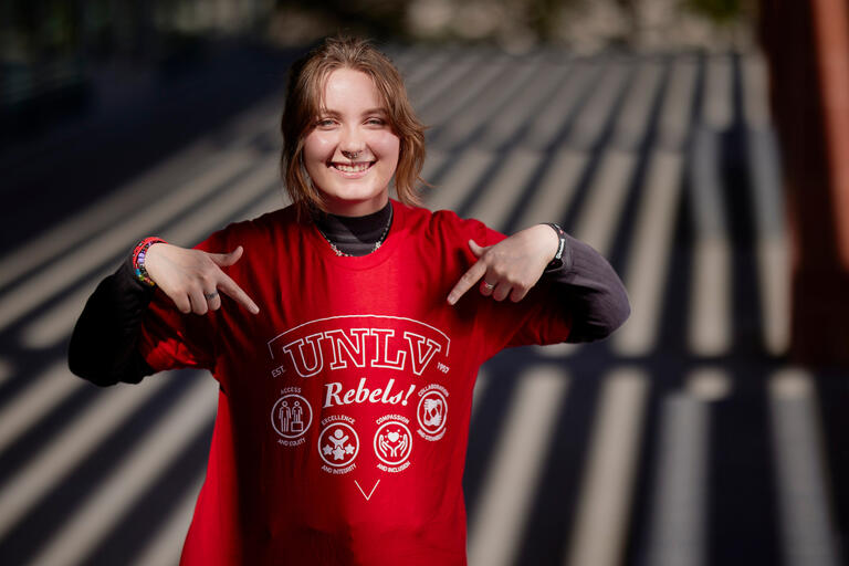 young female student points to design on red t-shirt